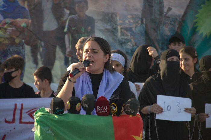 Reham Hico, Sprecherin der Befreiungsbewegung êzîdischer Frauen (TAJÊ), hält eine Rede bei der Gedenkdemonstration am 3. August 2024 in der Stadt Shingal.