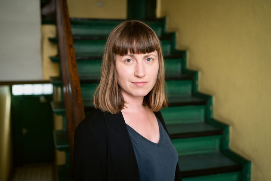 Porträtfoto von Paula Fürstenberg, im Hintergrund eine Treppe.