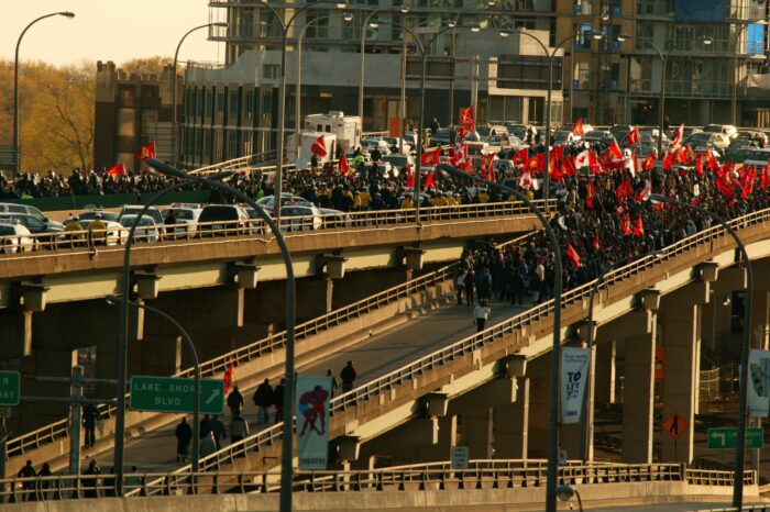 Protest von Tamil*innen in Toronto, die den Gardner Expressway blockieren. Zu sehen sind unter anderem Fahnen der Liberation Tigers of Tamil Eelam (LTTE).