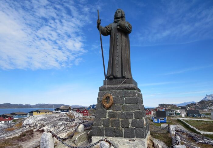 Man sieht vor blauem Himmel und Meer eine Statue.